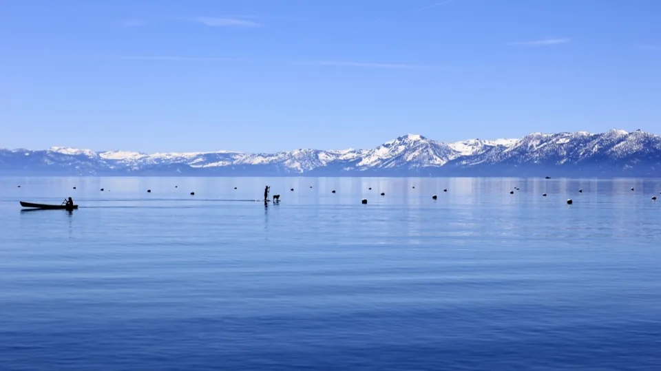 A quiet blue lake beneath snow-covered mountains